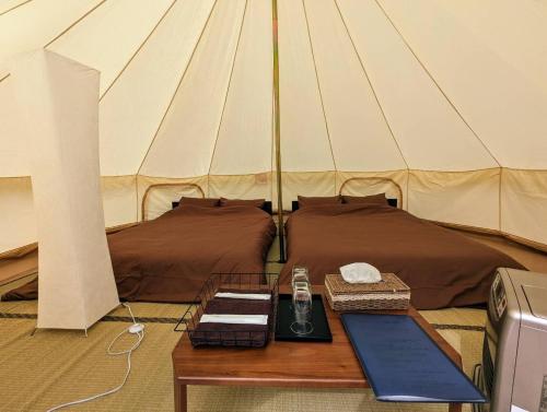 美作Glamchette Okayama -Glamping & Auto Camp- - Vacation STAY 19606v的一间设有两张床的房间和一张帐篷内的桌子
