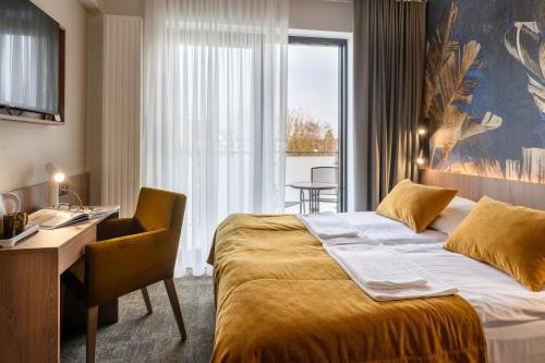 加茨比亚格拉Dom Wczasowy Zew Morza的配有一张床、一张书桌和一扇窗户的酒店客房