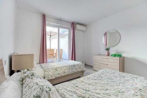 斯利马Brand New 2 Bed 2 Bath Apartment In Sliema By The Sea的一间卧室配有两张床和镜子