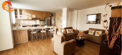 塔克纳NatAle Residencial - Departamento Segundo Piso con cochera的客厅以及带沙发和桌子的厨房。