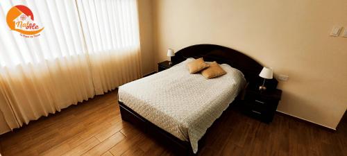 塔克纳NatAle Residencial - Departamento Primer Piso con cochera的一间卧室配有一张带两个枕头的床