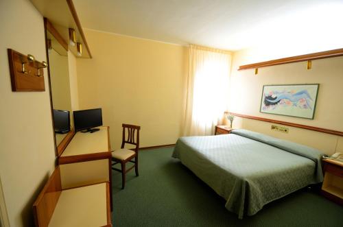 罗卡迪梅佐阿尔罗切大酒店的酒店客房配有一张床、一张桌子和一把椅子。