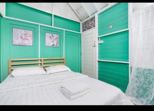丹那拉打Hillside cottage chalet studio的一间拥有绿色墙壁和一张大床的卧室