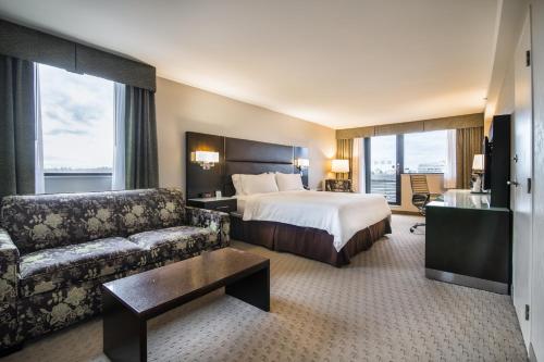 温哥华温哥华中心百老汇假日酒店的酒店客房,配有床和沙发