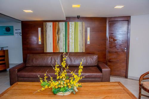 纳塔尔Garbos Soleil Hotel的客厅里一张棕色的皮沙发,配有桌子