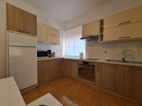 普拉Ferienwohnung für 4 Personen ca 64 qm in Pula, Istrien Istrische Riviera - b61675的厨房配有木制橱柜和白色冰箱。