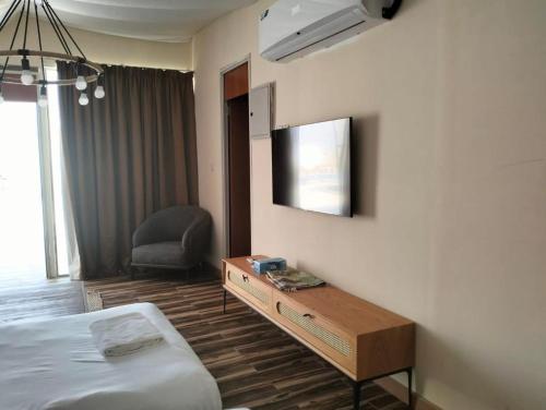 Al ḨamrānīyahDesert Breeze的酒店客房设有一张床、一张书桌和一台电视机。