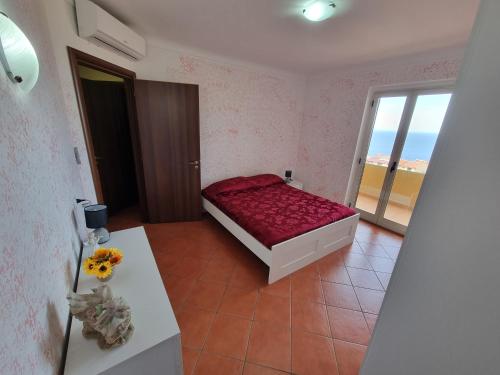 希拉Casa Vacanze Matteotti di Scilla的一间卧室配有一张床、一张桌子和一个窗户。