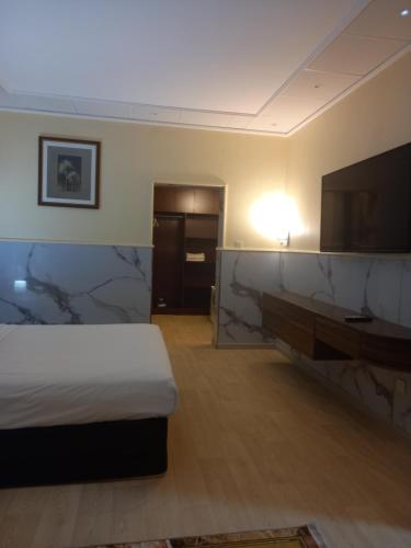 拉斯阿尔卡麦Holiday Homes的配有一张床和一台平面电视的酒店客房