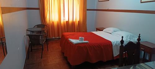 特鲁希略HOTEL LAS GARDENIAS的一间卧室配有一张带红色毯子的床