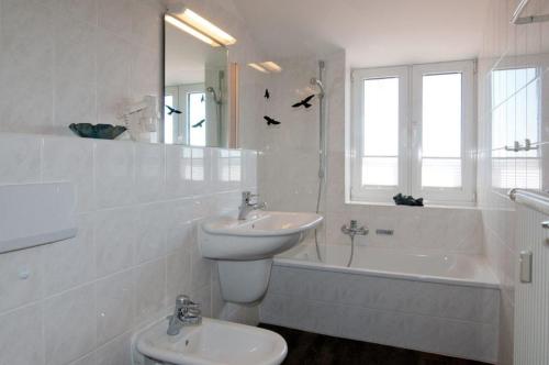 赫亨基尔兴Fewo Inselblick am Ostseestrand的白色的浴室设有水槽和卫生间。