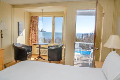 拉马巴耶三只鸭旅馆的一间卧室配有一张床、两把椅子和一个窗户