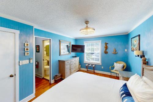 基韦斯特Old Town Garden Villas - Andros Suite的蓝色卧室配有一张床和一张书桌