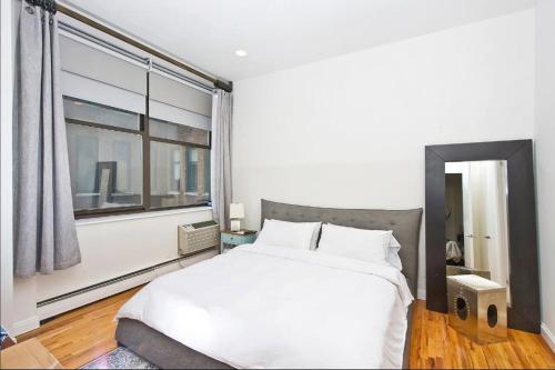 纽约Amazing 1300sf Loft By Union Sq的卧室设有白色的床和大窗户