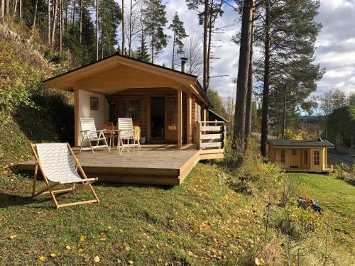 Ferienhaus in Västerrå mit Garten und Terrasse的小屋设有轻便折叠躺椅和椅子,位于草地上