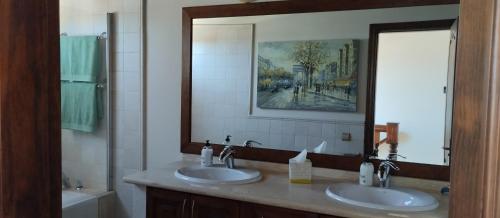 罗萨里奥港AKASHA的一间带两个盥洗盆和大镜子的浴室