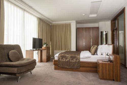 萨拉热窝Hotel R的配有一张床和一把椅子的酒店客房
