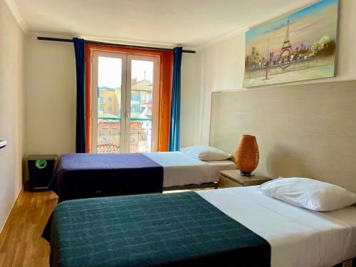里斯本Lisbonaccommodation的酒店客房设有两张床和窗户。