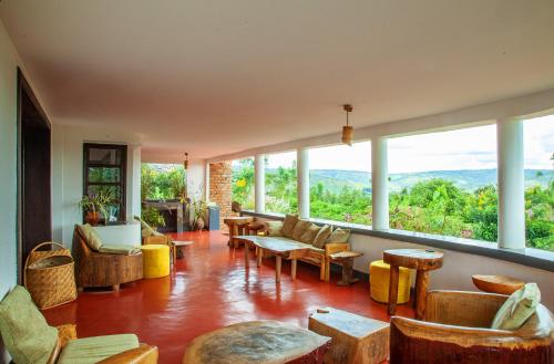 RwinkwavuRutete Eco Lodge的客厅配有桌椅和大窗户