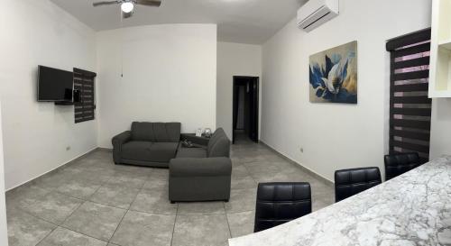 彼德拉斯内格拉斯Departamento moderno cómodo y céntrico的客厅配有沙发和椅子