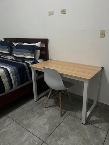 彼德拉斯内格拉斯Departamento moderno cómodo y céntrico的一张桌子和一张椅子,位于床边