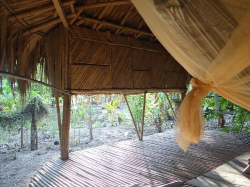 San OnofreEco-Camping Mango Feliz Rincón del Mar的木门廊,带窗帘和木板路