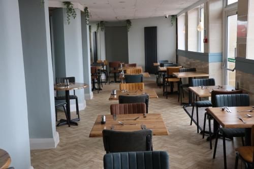 布莱克浦巴尔摩拉尔酒店的用餐室配有木桌和椅子