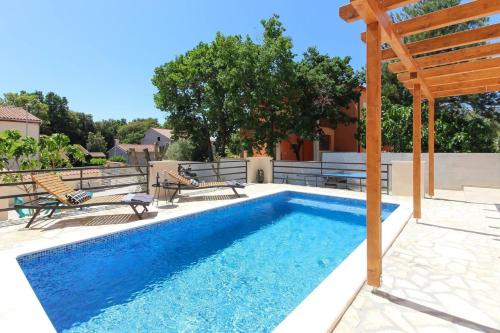 巴尔巴里加Ferienhaus mit Privatpool für 6 Personen ca 85 qm in Barbariga, Istrien Istrische Riviera的一座带木凉亭的游泳池位于一座房子旁边