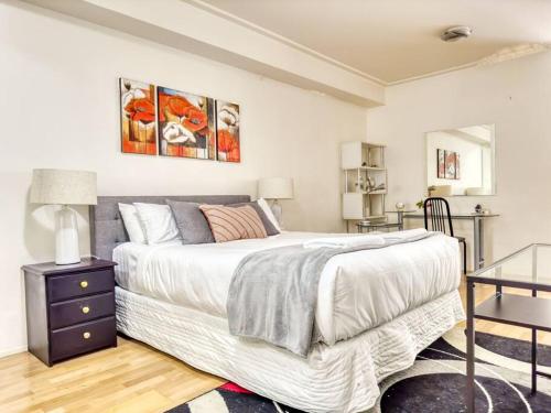 悉尼Superb Apartment in an Heart of Sydney' CBD的卧室配有一张白色的大床和一张桌子