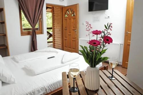 布达佩斯坎平恩&文迪嘉斯宾馆的一间卧室配有一张床和一张桌子及一杯葡萄酒
