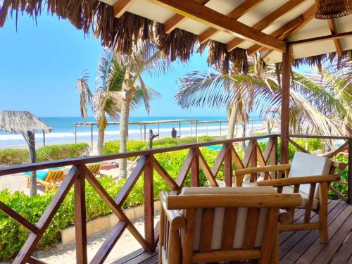 维加伊托El Refugio de Vichayito的配有椅子的甲板,享有海滩美景