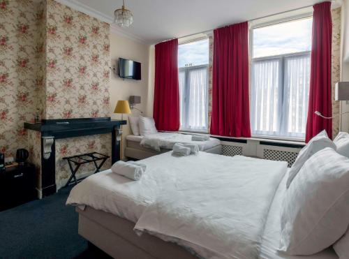 安特卫普Hotel Rubenshof的酒店客房,设有两张床和红色窗帘