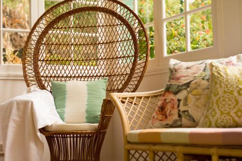 圣维森特卡萨达皮耶达德酒店的靠着带窗户的椅子的带枕头的柳条椅
