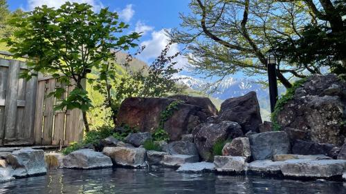 松本Nakanoyu Onsen Ryokan - Vacation STAY 18789v的院子里水中的一块岩石
