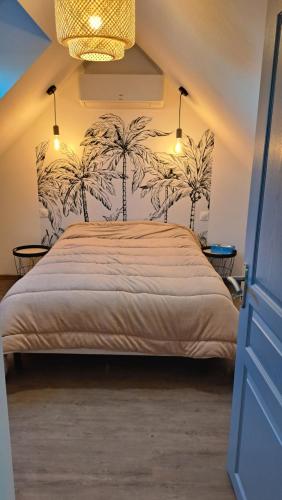 Mareuil-sur-CherAu Cœur des vignes的卧室配有一张墙上棕榈树床。