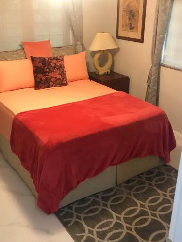 自由港市The Haven Hideaway & Platinum的一间卧室配有红色和橙色枕头的床