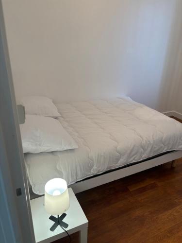 韦尼雪Appartement des merveilles的一张带白色毯子和边桌的床