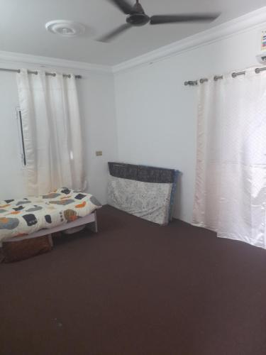 Şūr Maşīrahشقة في جعلان ( بيت عربي) اجار يومي واسبوعي的一间卧室配有床和两个带窗帘的窗户