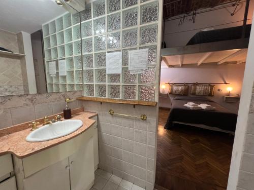 布宜诺斯艾利斯Centro de Buenos Aires的一间带水槽的浴室和一张位于客房内的床