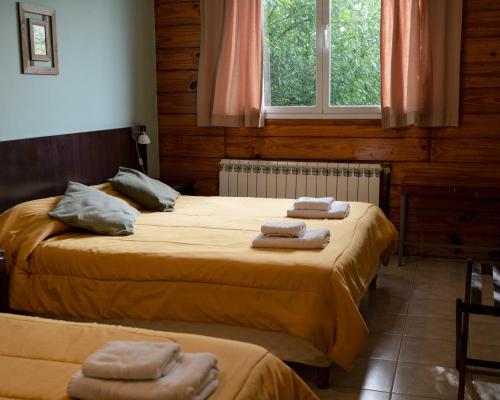 埃尔卡拉法特Folk Suites的客房内的两张床和毛巾