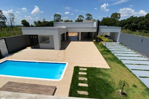 塞蒂拉瓜斯Sítio Gilmar2filhas的一座房子前面设有游泳池