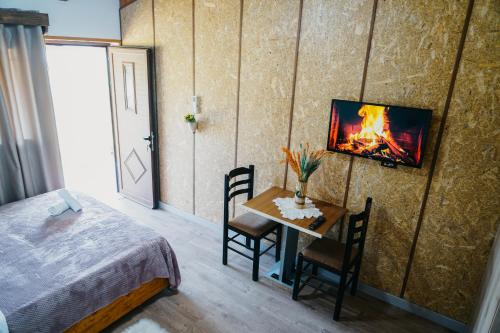 吉诺卡斯特Bujtina ANLU的一间卧室配有一张床和一个带壁炉的桌子