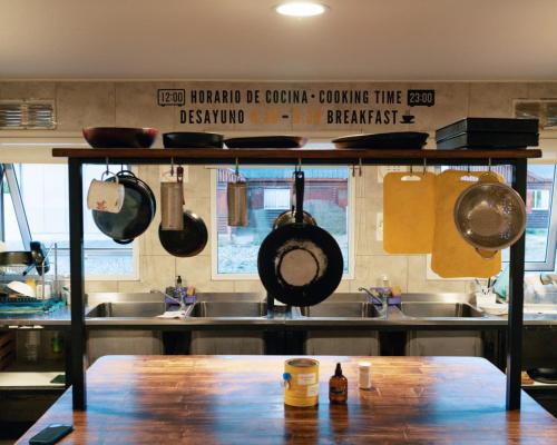埃尔卡拉法特Folk Hostel的厨房配有挂在架子上的锅碗瓢盆