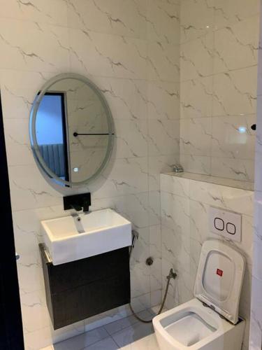 拉各斯Loft and Luxe Apartment的一间带水槽、卫生间和镜子的浴室