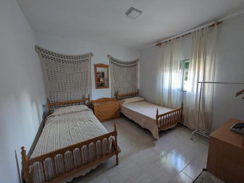 阿尔奇多纳Casa Virgen de Gracia的一间卧室设有两张床、一张桌子和一个窗口。