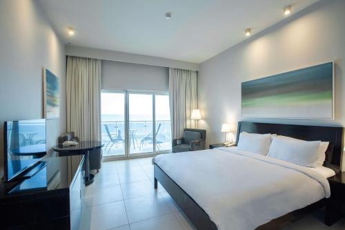 迪巴富吉拉丽笙度假酒店的一间带大床的卧室和一个阳台