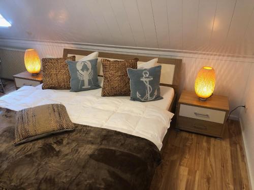 普鲁滕Ferienhaus Boddenblick mit Sauna的一间卧室配有一张带枕头的床和两盏灯。
