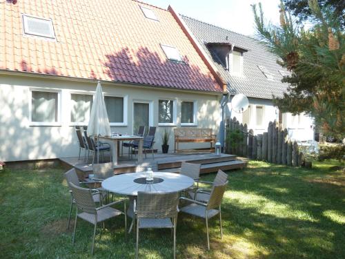 普鲁滕Ferienhaus Boddenblick mit Sauna的庭院里设有桌椅