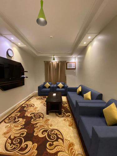 艾卜哈الخيال للوحدات السكنية的客厅配有蓝色的沙发和电视