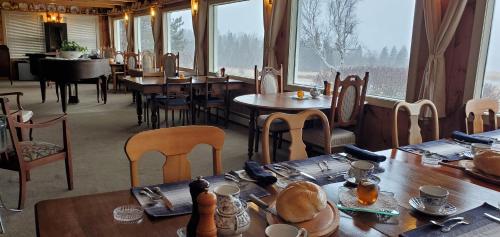 LornevilleAmherst Shore Country Inn的餐厅设有桌椅和大窗户。